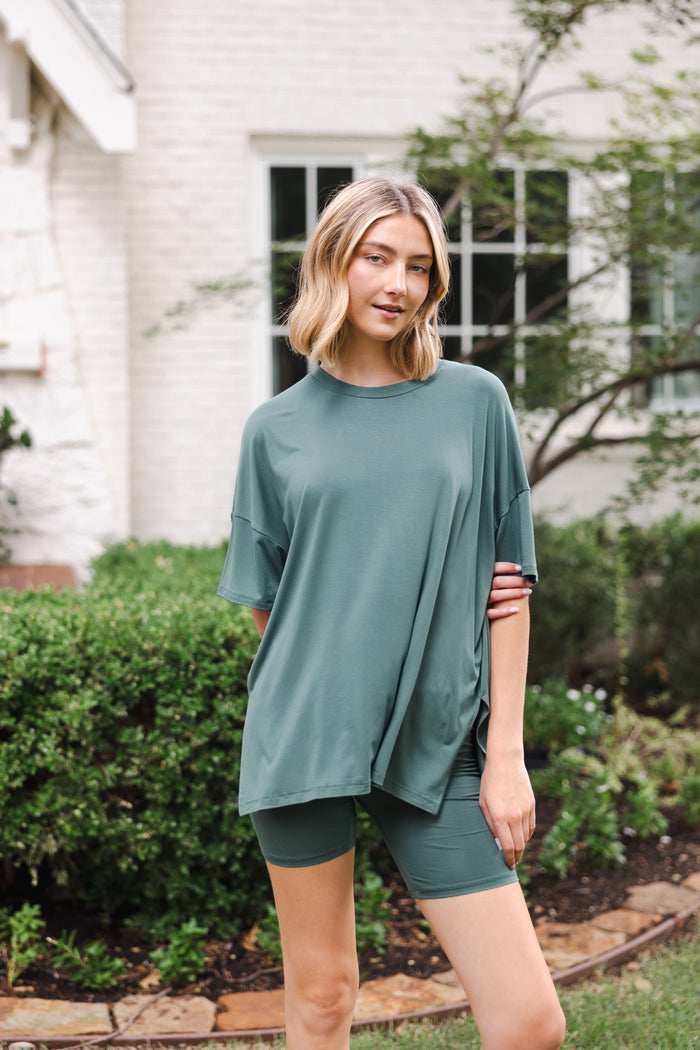 Modal wearing Women’s Biker Short Set in Pine outdoors in a garden