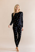 Model wearing Women's Jogger Pajama Set in Midnight Wildflower print on beige background