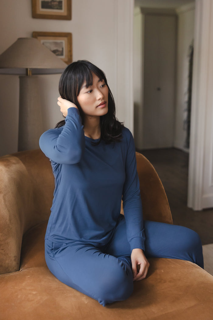 Modal wearing Women's Jogger Pajama Set in Oxford sitting on a brown sofa