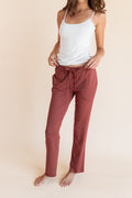 Model wearing Women's Lounge Pants in Ember under white camisole on a beige background