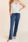 Model wearing Women's Lounge Pants in Oxford under a white camisole on a beige background