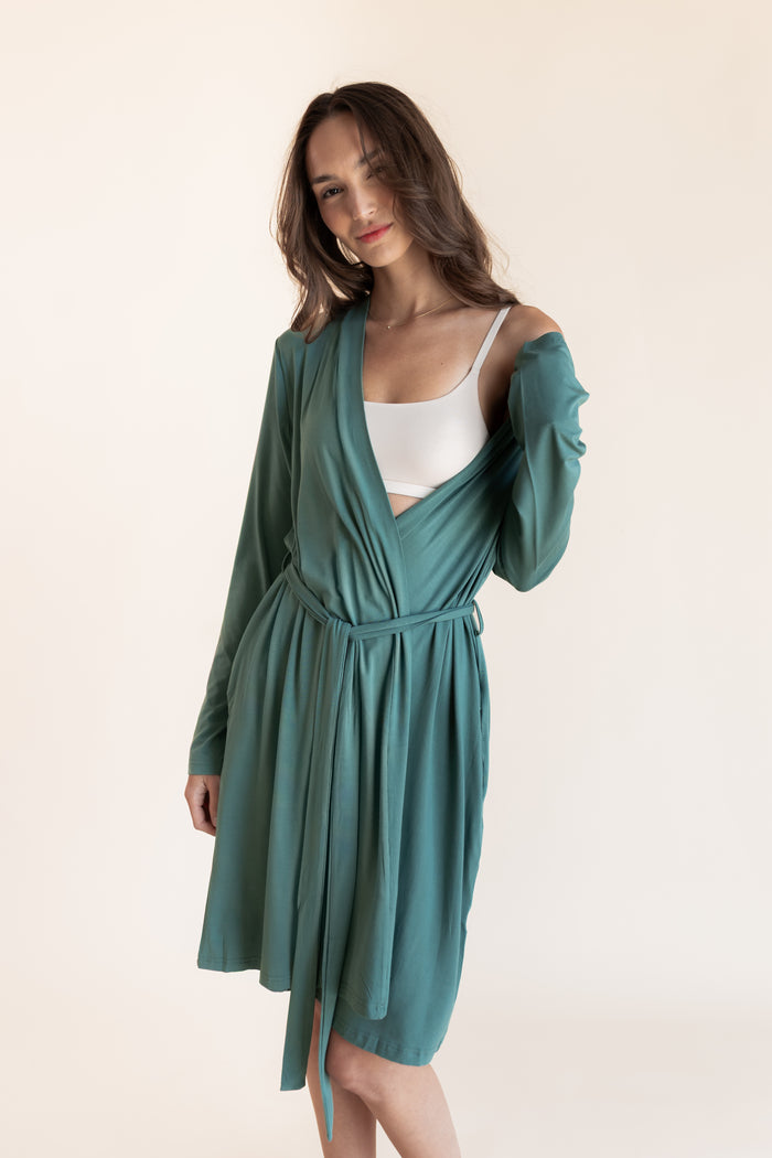 Model wearing Women's Lounge Robe in Pine over white bralette on a beige background