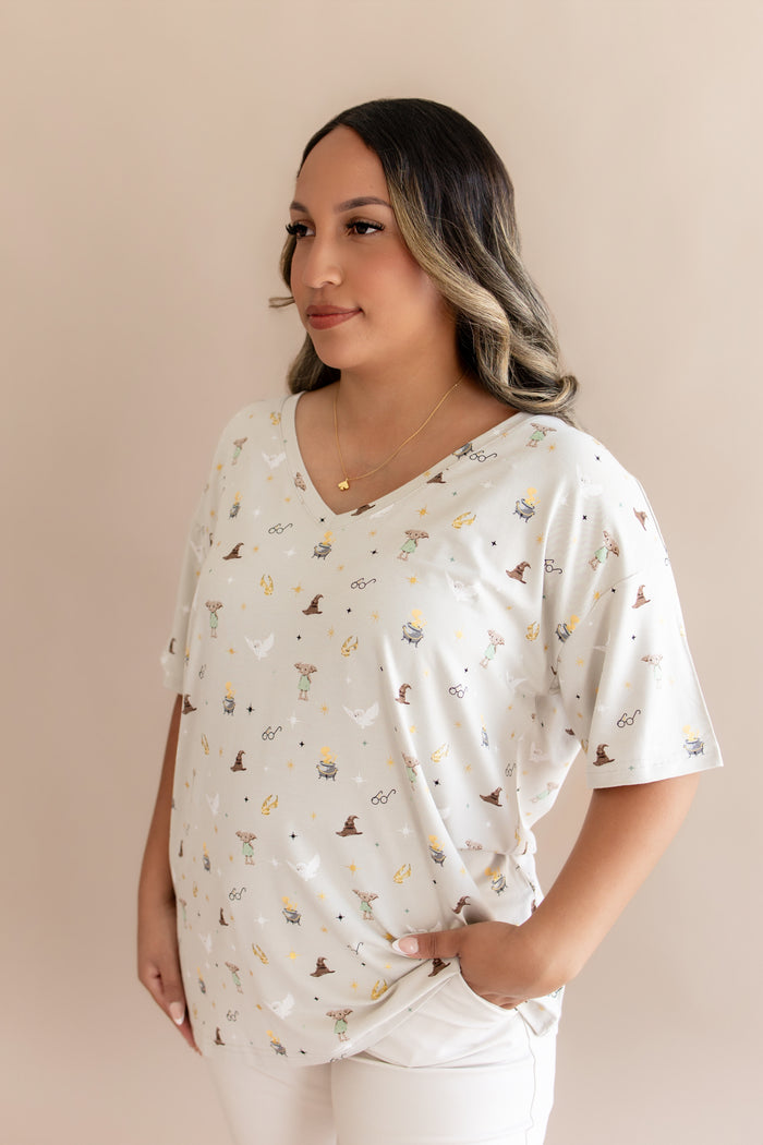 Model wearing a cream Harry Potter patterned Women's Relaxed Fit V-Neck on a beige background.