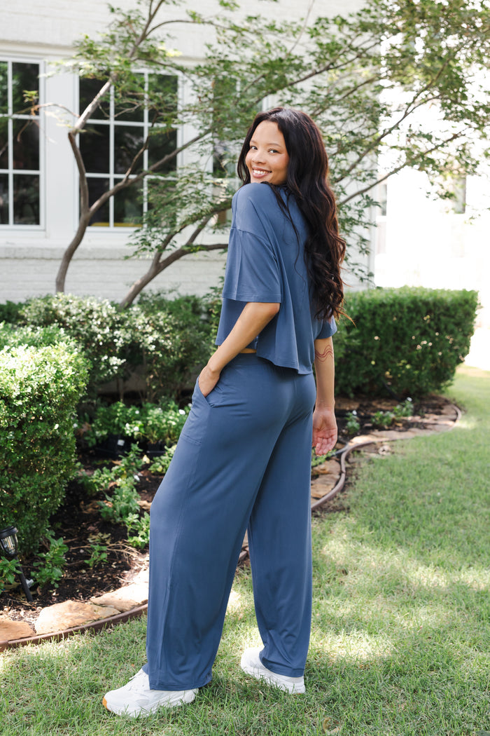 Modal showcasing back side of Women's Wide Leg Pant in Oxford standing outdoors in a garden