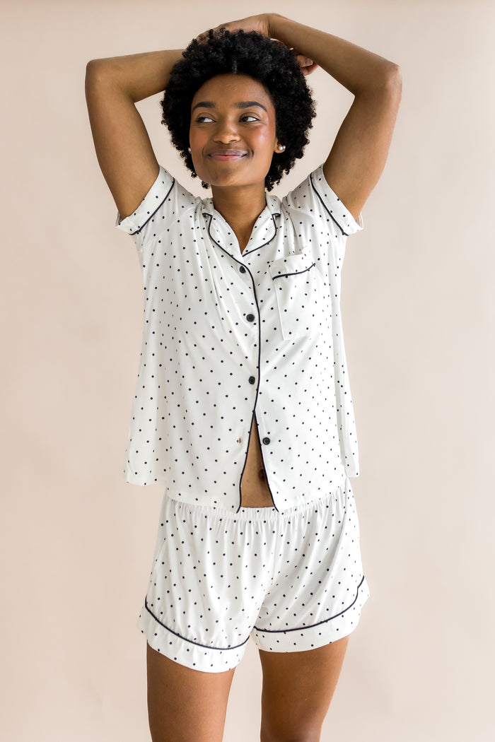 Model smiling in Women's short sleeve pajama set with Midnight Polka Dot print on a beige background