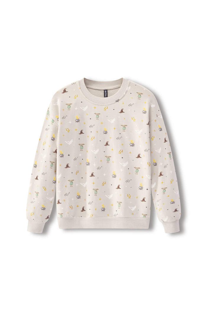 A cream-colored crewneck sweatshirt with an all-over print of small whimsical illustrations, including wizards, cauldrons, stars, and moons, displayed on a clean white background.